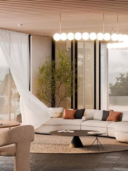 The living area of a villa at "Hillucinations," with a curved sofa, natural textures, and floor-to-ceiling windows that frame the stunning valley view.