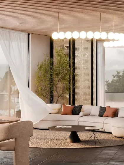 The living area of a villa at "Hillucinations," with a curved sofa, natural textures, and floor-to-ceiling windows that frame the stunning valley view.