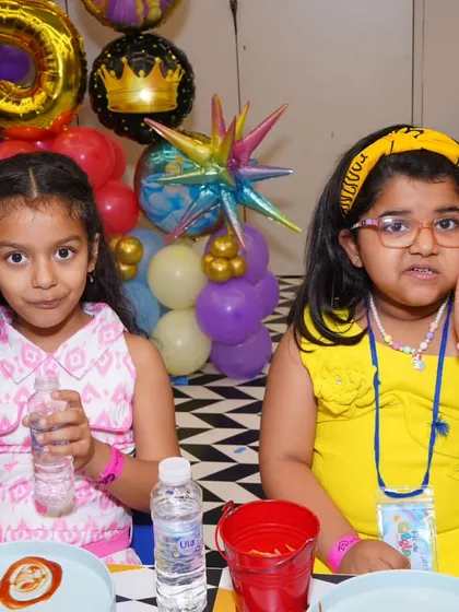 Giggles, glitter, and good vibes only! These two girls are enjoying the party atmosphere, with colorful balloons and fun decor all around them. My aim is to create a joyful and festive environment.