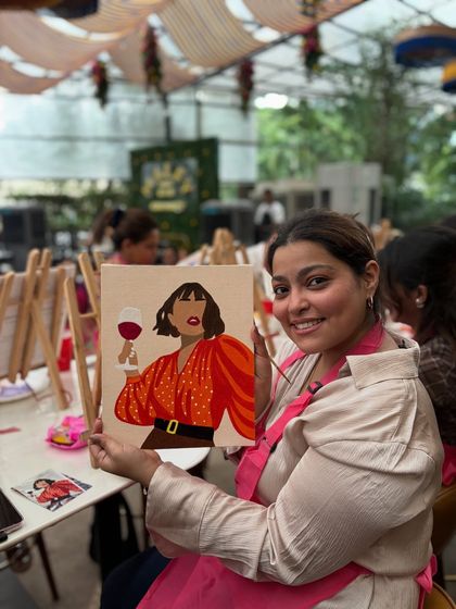A guest at Nicole Concessao's birthday party proudly holding her finished artwork. I love seeing the personal touches everyone adds to their paintings.
