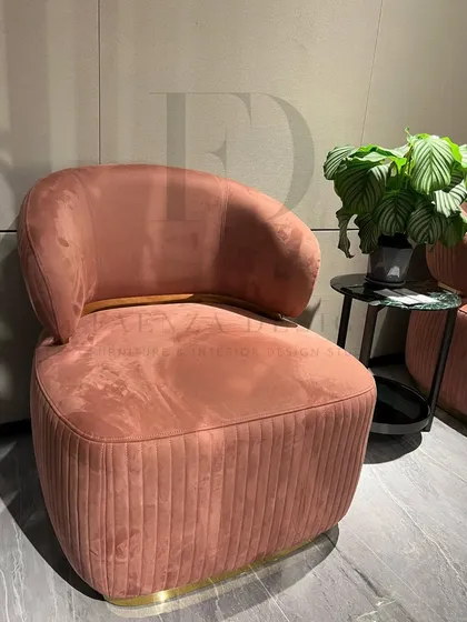This armchair in a soft peach-colored velvet features a pleated back and a metal-accented base. It's a beautiful example of combining soft textures with strong, modern details.