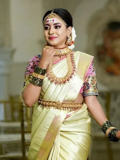 A graceful pose that showcases the full bridal set, including the long braid adorned with traditional hair accessories.