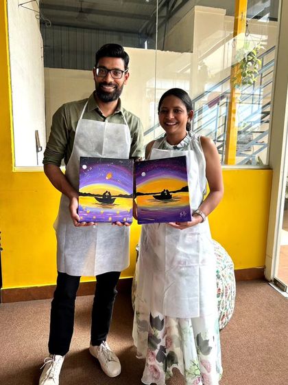 A happy couple showing off their complementary paintings. They each painted one half of a whole scene, a beautiful symbol of their connection.