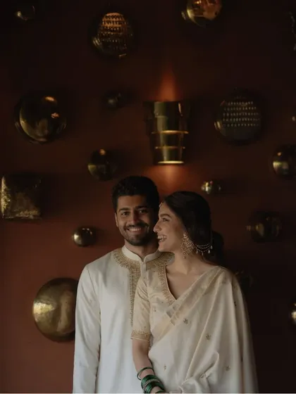 A smiling portrait against a beautifully decorated wall. This pre-wedding photo perfectly balances elegance and happiness, showcasing the couple's style and connection.