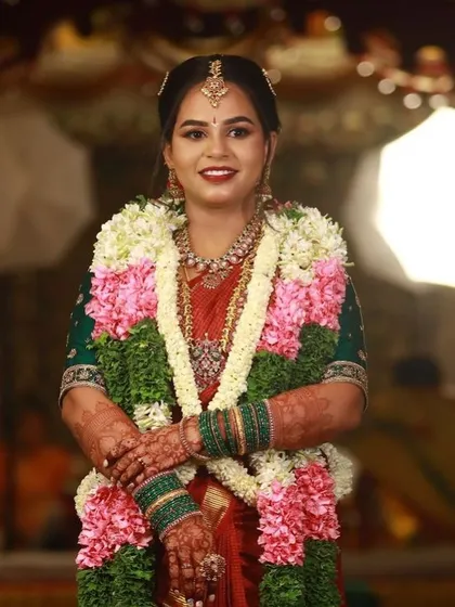 A beautiful portrait of the bride during her wedding ceremony, adorned with garlands and a rich mehendi stain.