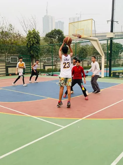 A player takes a shot while a teammate looks on, ready for the rebound.