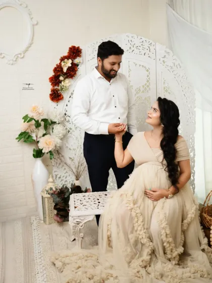 A beautiful couple's portrait from a light and airy maternity session. The off-white gown and delicate props create a soft, romantic, and timeless feel.
