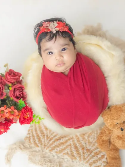 This awake and alert newborn is wrapped in a bold red swaddle, looking right at the camera. We capture both sleepy and awake moments.