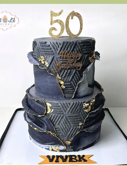 A bold and dramatic two-tiered cake for Vivek's 50th birthday. The black textured design is accented with gold leaf for a luxurious feel.