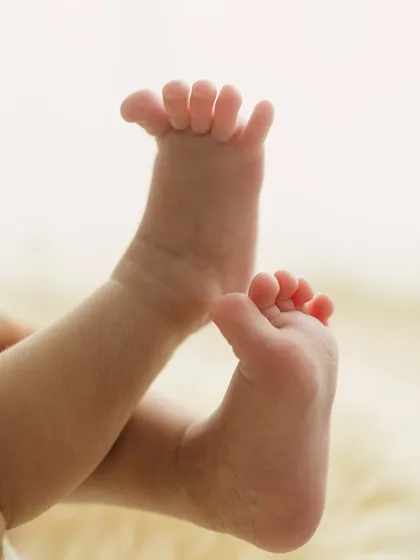A little stretch. This photo captures the sweet, unposed movement of a newborn's feet, a memory of their sleepy, curly stage.