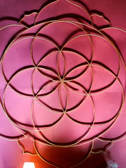 The 'Flower of Life' motif, a central element in our Anant theme, rendered in gold against a rich pink backdrop. This symbol of creation and unity adds a layer of deep meaning to the decor.