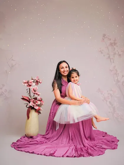 A fairytale moment between a mother and daughter. The flowing gown and dreamy, sparkling background create an elegant and magical portrait.