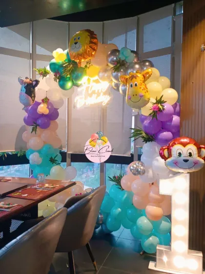 A compact jungle-themed balloon setup for a restaurant party, perfect for a first birthday photo corner.