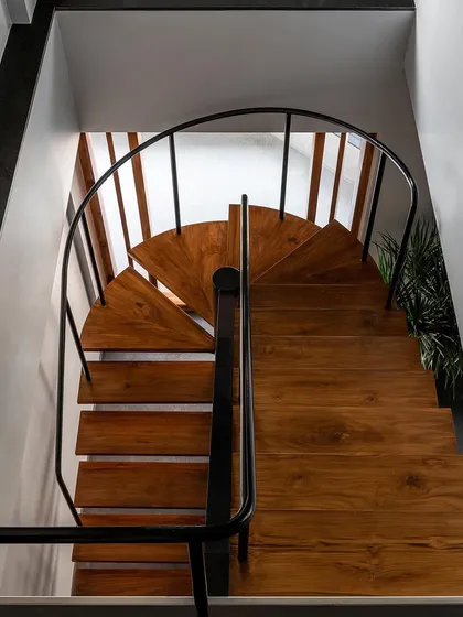 This custom staircase is a centerpiece, not just a utility. I replaced a bulky concrete structure with this lighter, open-riser design in metal and solid timber, allowing sunlight to flow freely through the duplex home.