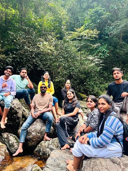 Relaxing on the rocks by a stream, a peaceful moment during our exploration of Munnar's natural beauty.