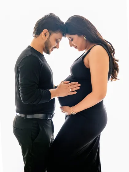 Sometimes, the most powerful portraits are the simplest. This intimate moment between a couple, captured against a clean studio backdrop, focuses purely on the connection and anticipation of their new arrival.