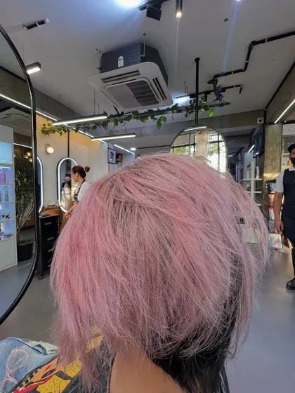 A top-down view of the baby pink hair, showing the texture and playful nature of the color and cut.