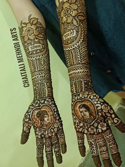 Another example of my custom portrait work for a bride. The faces of the couple are framed in hearts on the palms, with their names, Aniket and Bharti, written above on the wrists.