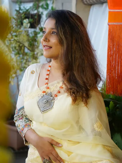 This shot captures the delicate, airy feel of the organza saree and the striking contrast of the bold silver jewelry.