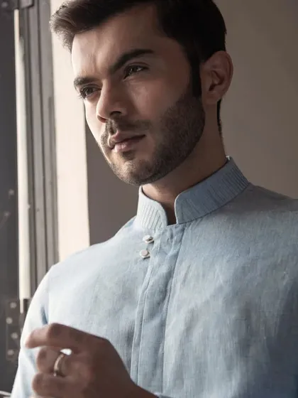 A portrait of a model in the blue linen shirt, capturing its effortless summer elegance.
