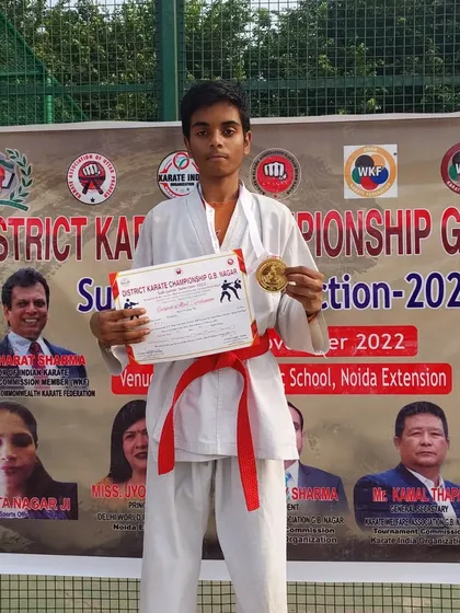 Shiva Kumar on the podium after winning a gold medal at the District Karate Championship G.B. Nagar Sub-Junior Selection 2022.