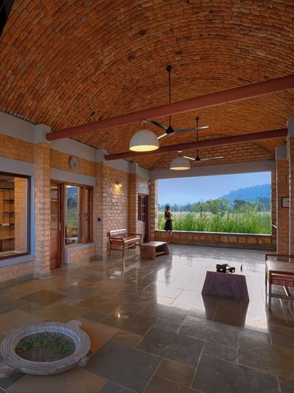 The welcome lounge at Waghoba Ecolodge, featuring a vaulted roof made with local pottery tiles and walls of stabilized adobe. The open design frames a panoramic view of the distant hills, immediately immersing guests in the natural setting.