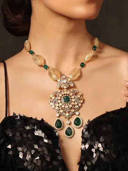 A contemporary masterpiece. This necklace features a unique pendant with emeralds and polki, strung on a beaded chain of yellow stones for a modern, chic look.