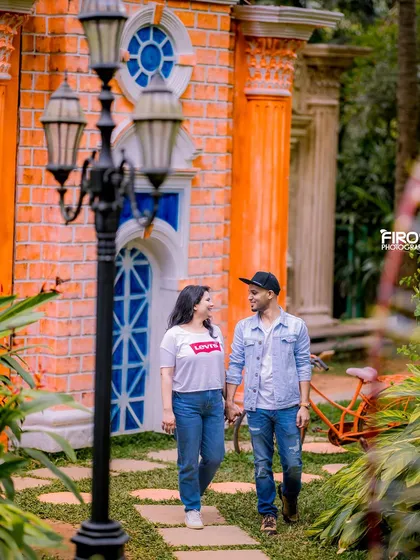 A couple walks hand-in-hand down a garden pathway, a perfect candid-style shot.