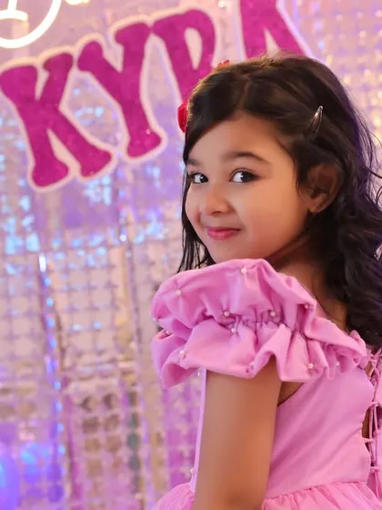 A charming over-the-shoulder glance from the birthday girl. Our approach to kids' photography is to engage with them and capture their natural personality.