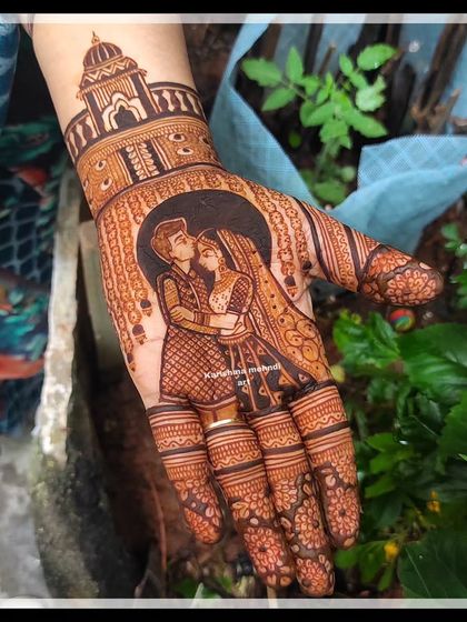 A romantic couple portrait on the palm, set against a backdrop of grand temple architecture. This design combines personal portraiture with classic bridal motifs for a complete and beautiful look.