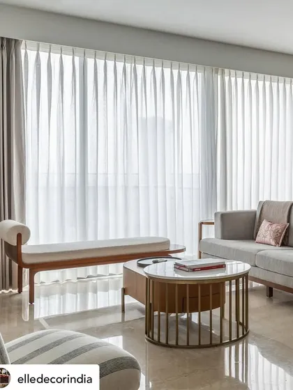 A glimpse into our 'House Nandini' project as featured in Elle Decor. The living room is bathed in natural light, where we used sheer curtains to create a soft, ethereal glow, highlighting the clean lines of the contemporary furniture.