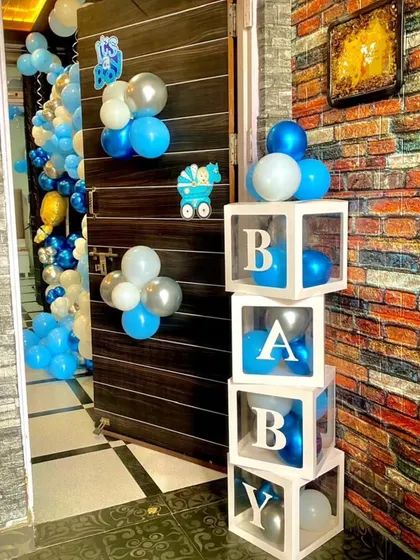A simple yet charming decoration detail for a baby boy's welcome. These 'BABY' blocks filled with blue balloons are placed by the door to greet the newborn.