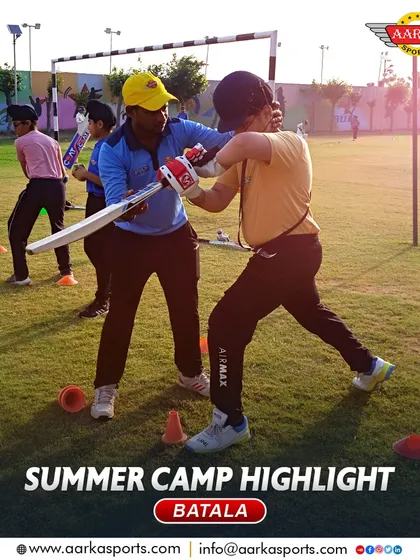 A coach provides hands-on correction to a young player's batting stance during our summer camp. This attention to detail is what makes a difference.
