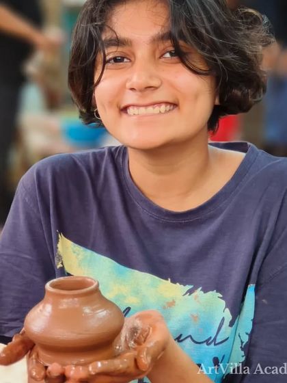 The proud smile of a student with her first wheel-thrown pot. There is nothing like the feeling of creating something beautiful with your own hands.