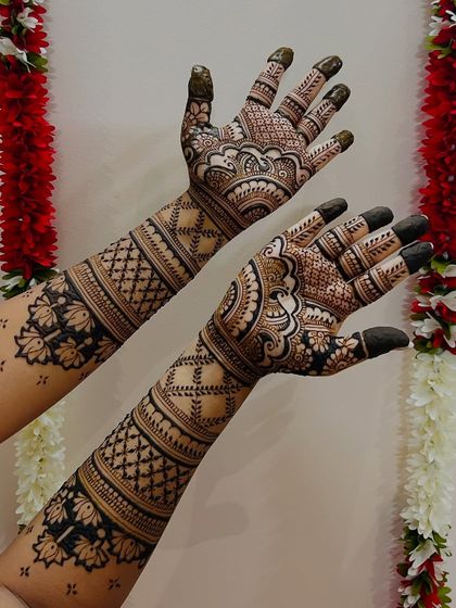 A full-arm design with a festive background. The patterns include lotus motifs and traditional check designs for a classic bridal feel.