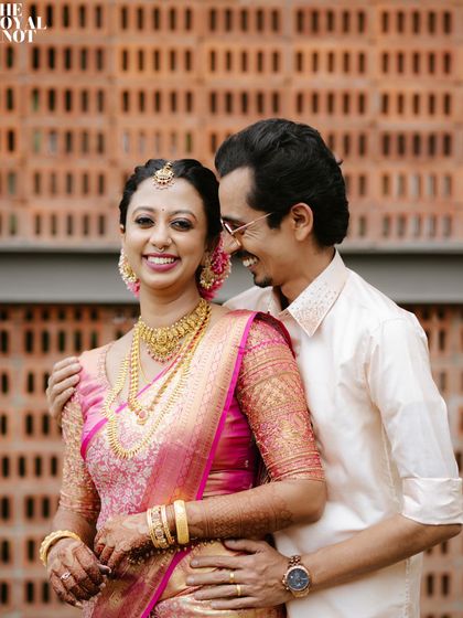 The happiness of a newly married couple. The bride's pink silk saree is draped in a classic style, perfect for a traditional wedding ceremony.