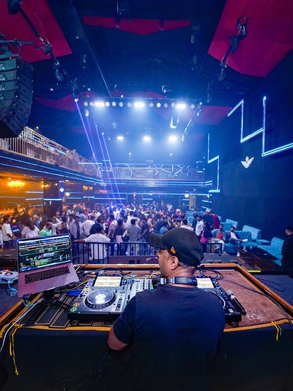 This is my command center. From this console, I control both the music and the visuals you see on the screen, ensuring every beat drop is matched with a powerful visual cue for maximum impact.