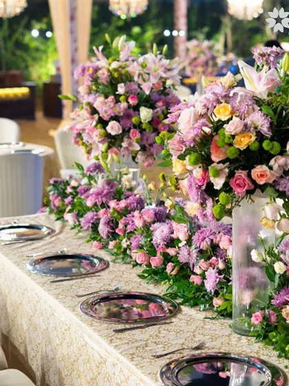 A long table adorned with a lush runner of purple and pink flowers at our Worli venue. This setup demonstrates how we use florals to create a dramatic and beautiful dining experience.