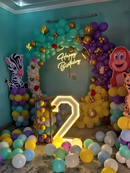 A different perspective of the jungle-themed setup, focusing on the circular balloon arch and neon sign.