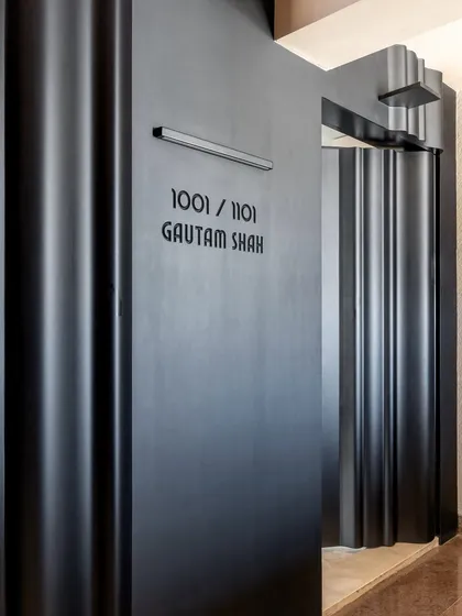 Another view of the dramatic entrance, showcasing the interplay of light and shadow on the fluted surfaces. The design is modern, bold, and architectural.