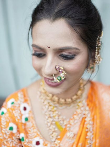 A close-up bridal portrait, focusing on her beautiful makeup and the traditional nath.