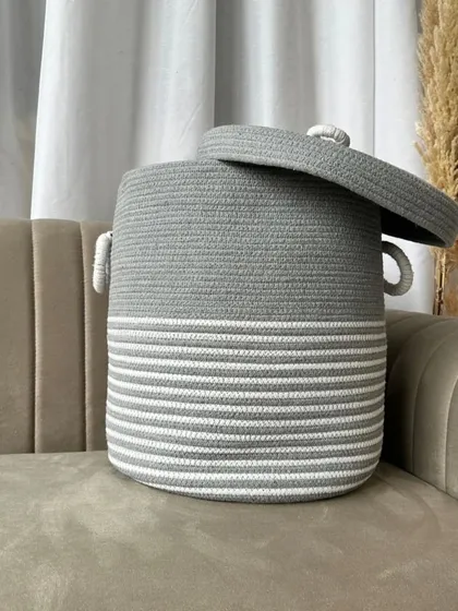 This grey and white striped laundry basket is another chic option for home organization, complete with handles for easy carrying.