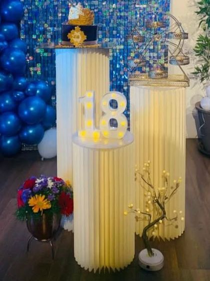A close-up of the 18th birthday cake and marquee numbers against the royal blue shimmer wall.