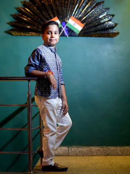 A patriotic touch in this birthday portrait, with the Indian flags in the background adding a unique element to the photoshoot.