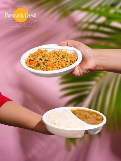 Using a bold, pink background and tropical leaf shadows, this shot makes these ready-to-eat meals look fresh and exciting. The hands passing the food add a human element and a sense of action.