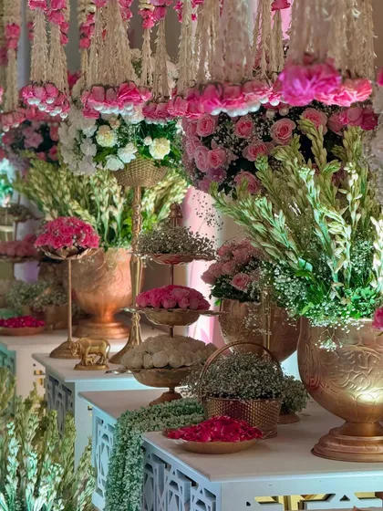 A beautiful arrangement of flowers and traditional elements on a decor table. The mix of textures, from the soft petals to the metallic vases, is a feast for the eyes.