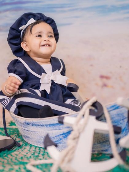 A happy smile from the captain's seat. This photo shows how babies can comfortably sit and play in our boat prop, leading to genuine and joyful expressions.