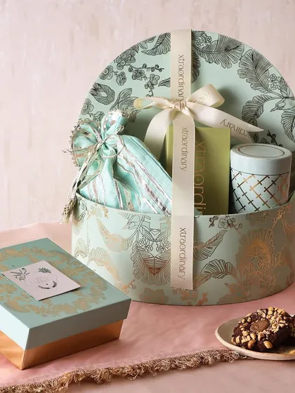 The Minted Joy hamper is a refreshing take on festive gifting. It includes hazelnut cookies, sugar-free mithai, and a choice of a vanilla tea cake or a candle, all in a beautiful mint green box.