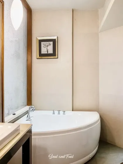 A modern hotel bathroom featuring a clean white bathtub and sink. The neutral tones and simple design create a relaxing and spa-like environment for guests.