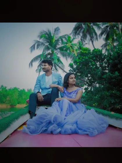 A cinematic shot of a couple on a boat, looking out at the scenery. The flowing lavender-blue gown adds to the dreamy, romantic feel.